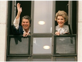 U.S. President Ronald Reagan waves to the press in 1987, from the window of his room at Bethesda Naval Hospital. He had just had surgery.