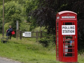 Photo of the day: A polling station sign is posted on a telephone box outside the polling station at Rotherwick Hall, west of London, on June 8, 2017, as Britain holds a general election.