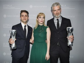 Xavier Dolan, left, holds up her Iris trophy for best director and best film for Juste la fin du monde with producers Nancy Grant and Sylvain Corbeil at the Quebec Cinema awards ceremony in Montreal, Sunday, June 4, 2017.