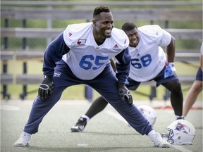 MONTREAL, QUE.: MAY 29, 2017 -- Montreal Alouettes offensive linemen Jovan Olafioye smiles while stretching at training camp at Bishop's University in Lennoxville, southeast of Montreal Monday May 29, 2017.  Philip Blake is in background. (John Mahoney / MONTREAL GAZETTE) ORG XMIT: 58690 - 1216
John Mahoney, Montreal Gazette