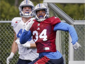 Linebacker Kyries Hebert, right, and fullback Jean-Christophe Beaulieu track the flight of a pass intended for Beaulieu during Alouettes training camp at Bishop's University in Lennoxville in May.
