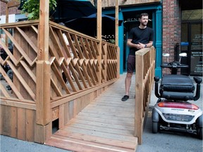 Charles-Etienne Begin, a partner in Renard, a bistro in the gay village, stands on his ramp in Montreal on Monday July 3, 2017. The city has deemed the terrace is too high, which Renard made level with the bistro floor to allow wheelchair access.