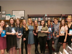 Beaconsfield High School English teacher Melinda Cochrane, pictured centre in blue dress, poses with student editors and published authors from her Writer's Room course.