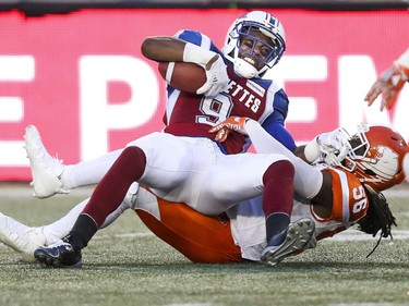 Montreal Alouettes receiver Ernest Jackson lands on British Columbia Lions Solomon Elimimion after making a catch during first half of Canadian Football League game in Montreal Thursday July 6, 2017.