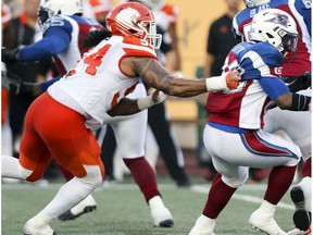 British Columbia Lions defensive lineman DeQuin Evans grabs Montreal Alouettes running back Tyrell Sutton during first half of Canadian Football League game in Montreal Thursday July 6, 2017.