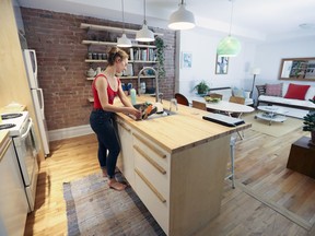 Erin O'Loughlin washes the dishes in the kitchen of the eastern Plateau apartment she co-owns with fellow contemporary dancer Geneviève Boulet. They opted for non-standard wooden handles for the cabinets of their IKEA kitchen. The floors in the apartment are the original hardwood.