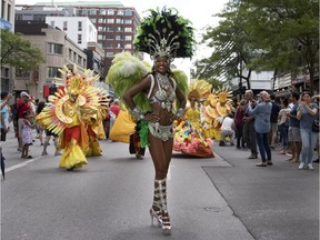 A dancer makes her way along Ste-Catherine St. as she takes part in the annual Carifiesta parade in Montreal on July 8, 2017.
