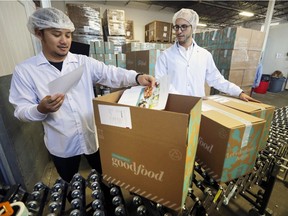 Goodfood CEO Jonathan Ferrari, right, checks in with production associate John Bryan Velez at the company's office in Montreal on Thursday, July 13, 2017.