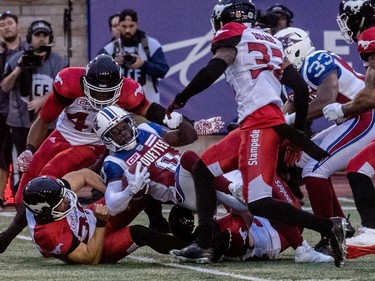 Alouettes running back Stefan Logan is brought down by the Calgary Stampeders at Molson Stadium in Montreal on Friday, July 14, 2017.