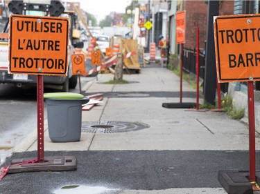 Several signs announce that the sidewalk on the south side of Notre-Dame Street is closed, despite two restaurants being opened for business just east of the closed notice, in Montreal, on Monday, July 17, 2017.