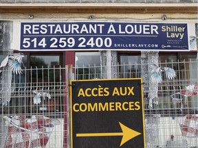 A shuttered restaurant is for rent behind a construction safety fence in Montreal in 2017.