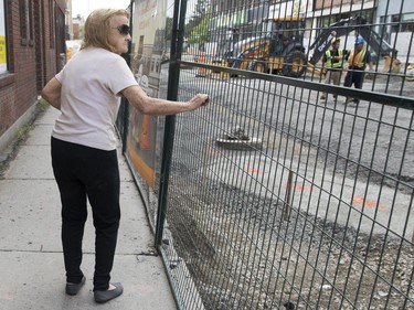 A woman pauses to rest and look at the ongoing construction on Notre-Dame Street in the Sud-Ouest district in Montreal, on Monday, July 17, 2017.