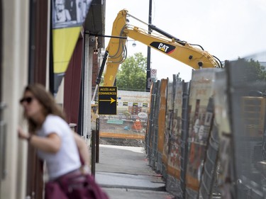 A woman checks the address of a residence on Notre-Dame Street as the infrastructure project continues along the strip west of Rose-de-Lima street in Montreal, on Monday, July 17, 2017.