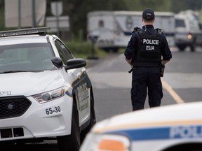 Longueuil police investigate a large wooded area after two men were found shot to death in Brossard July 18, 2017.