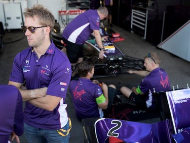 Sam Bird of Virgin Racing speaks with team members as mechanics assemble his race car during the open house for the Formula E in Montreal on Friday, July 28, 2017.