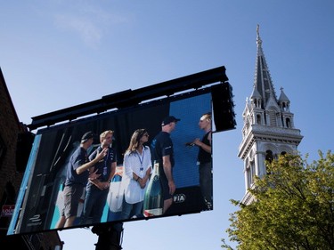 A large screen displays race action along Viger St. during the open house for the Formula E in Montreal on Friday, July 28, 2017.