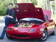 Michael DeVuyst poses next to his converted cherry-red 1990 Mazda Miata MX-5 near his home in Greenfield Park on Friday, July 28,  2017.  DeVuyst uses a dozen lead-acid batteries to power his new electric vehicle.