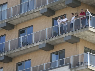 Neighbouring residents get to watch the Formula E qualifying from their balcony on René Lévesque St., on Saturday July 29, 2017. (Pierre Obendrauf / MONTREAL GAZETTE)