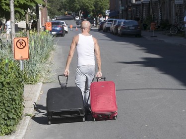 Man walks away from his home near the Formula E track, near the corner of Papineau Ave. and René-Lévesque St., prior to the practice round on Saturday July 29, 2017. (Pierre Obendrauf / MONTREAL GAZETTE)