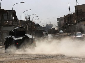 Iraqi forces patrol a street in west Mosul July 13, 2017.
