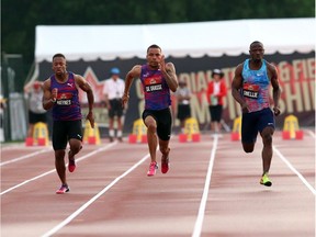 Andre De Grasse, centre, of Toronto sprints towards the finish line to win gold in the men's 100-metre race at the Canadian Track and Field Championships in Ottawa, Friday, July 7, 2017.