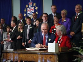 Premier John Horgan takes an oath with Lieutenant-Governor Judith Guichon as he's sworn-in as Premier during a ceremony with his provincial cabinet at Government House in Victoria, B.C., on Tuesday, July 18, 2017.