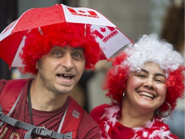 A man and a woman smile as they watch the annual Canada Day parade in Montreal, Saturday, July 1, 2017.