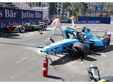 Sebastien Buemi, of Switzerland, checks the damage to his car after crashing into the barrier in the second practice session at the Montreal Formula ePrix electric car race, in Montreal on Saturday, July 29, 2017. THE CANADIAN PRESS/Tom Boland