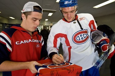 The Montreal Canadiens' Andrei Markov autographs a sweater for fan, Maxime Lefebvre,18, after practice at the Verdun Auditorium in Verdun, on Thursday, October 9, 2008.