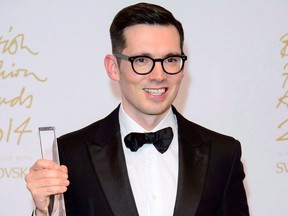 Designer Erdem Moralioglu poses for photographers with his Best Womanswear award at The British Fashion Awards 2014, in London, Monday, Dec. 1, 2014.