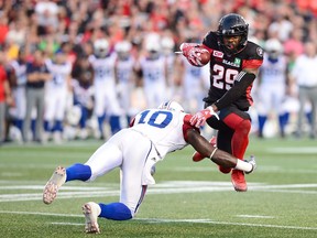 Redblacks running back William Powell (29) is tackled by Alouettes linebacker Chris Ackie (10) during first half CFL football action in Ottawa on Wednesday, July 19, 2017.