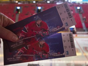A man holds up tickets prior to an NHL hockey game between the Montreal Canadiens and the Toronto Maple Leafs at the Bell Centre in Montreal, Saturday, February 9, 2013.