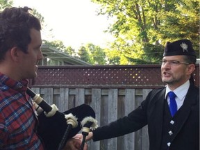 Jordi Anderson shows Christopher Curtis how to play the bagpipes.