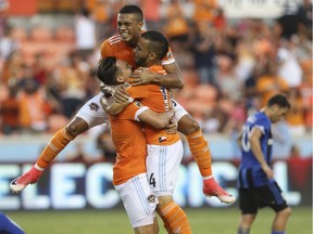 Dynamo forward Mauro Manotas (19) jumps onto Erick Torres (9) and Alex (14) after Alex scored a goal during the first half of a soccer game against the Impact, Wednesday, July 5, 2017, in Houston.
