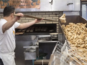 Fresh bagels are removed from the oven at the St-Viateur bagel shop, Sunday, May 21, 2017 in Montreal. Tourists have long ventured to Mile End in search of bagels, but these days, they are arriving en masse to walk around the area.