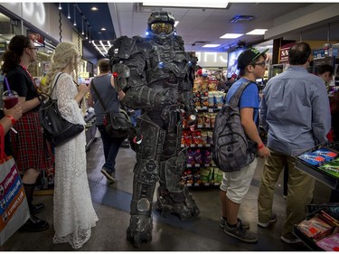 Frank Roy dressed as Master Chief of Halo Fame, waits in line of a convenience store in Montreal for a few drinks and a snack before he attends the Montreal Comiccon on Saturday, July 8, 2017.