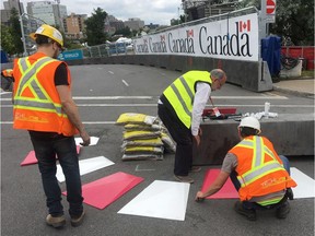 Workers put the finishing touches on the street course for the Montreal Formula ePrix race on July 27, 2017.