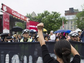 Police hold back demonstrators during a protest in Montreal, Saturday, July 1, 2017.