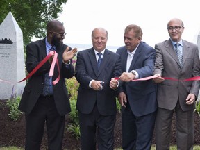 Yvan Rodrigue, second from the left, of Lepine Cloutier Athos, cuts the ribbon at the inauguration of a Muslim section of Les Jardin Quebec cemetery, Sunday, July 9, 2017 in Saint-Augustin-de-Desmaures. Rodrigue is flanked by Adam Diakite, president of Balimaya, from the left, Omar Chikh, director of Funeral Islamic Center and Mohamed Ouezzani family counselor for Funeral Islamic Centre for Magnus Poirier hold the ribbon.