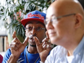 Saturday, July 8, 2017, Fo Niemi of Centre for Research-Action on Race Relations, right, listens at CRARR's Montreal offices as Pradel Content discussed his complaint that two Laval police officers violently arrested him without cause and erased a video of the incident from his cell phone on May 14, 2017.