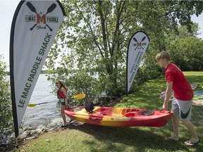 Callum Duff-Meadwell right, helps Karine Drouin left, as she sets out onto Lac St-Louis from the Mac Paddle Shack, in Ste Anne de Bellevue on Saturday, July 22, 2017. The Mac Paddle Shack offers hourly kayak and SUP board rentals, paddling instruction and paddle-board yoga classes to the general public as well as students. ,  (Peter McCabe / MONTREAL GAZETTE)