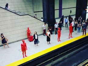 Performers in red body paint at the Sherbrooke metro station