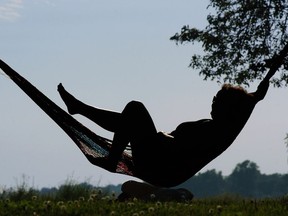 Lucie Charbonneau beats the heat with a book and a hammock in Fort-Rolland park in Lachine.