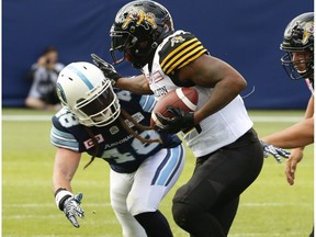Hamilton Tiger Cats C.J. Gable RB (32) is chased down by Toronto Argonauts Bear Woods LB (48) during the third quarter in Toronto, Ont. on Sunday June 25, 2017.