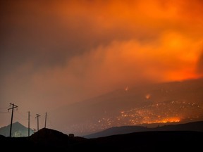 A wildfire burns on a mountain in the distance east of Cache Creek, B.C., in the early morning hours of July 10, 2017.