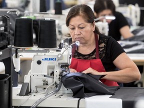 Khamlay Vongsiprasueuth works at a Canada Goose factory in Boisbriand on  June 29, 2017. Other local garment makers are calling on the government to protect a NAFTA provision.