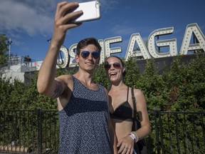 A couple take a selfie in front of the Osheaga sign at the Osheaga Music and Arts Festival at Parc Jean Drapeau in Montreal on Saturday, August 5, 2017.