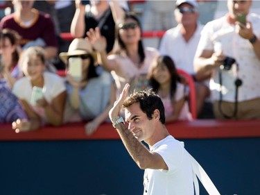 Roger Federer waves to cheering fans as arrives to practice on centre court during the Rogers Cup in Montreal on Saturday August 5, 2017.