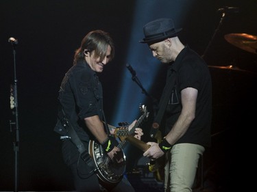 Keith Urban, left, performs in concert at the Bell Centre in Montreal, Saturday, August 12, 2017.