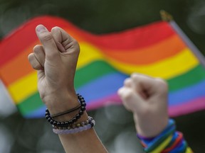 People raise their fists as they take part in a moment of silence during the Montreal Pride Parade in 2016.